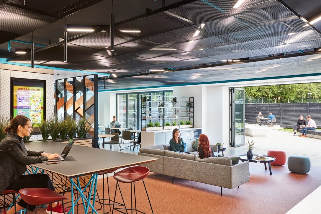 People are shown working within an open collaborative space, an office design trend on the rise.