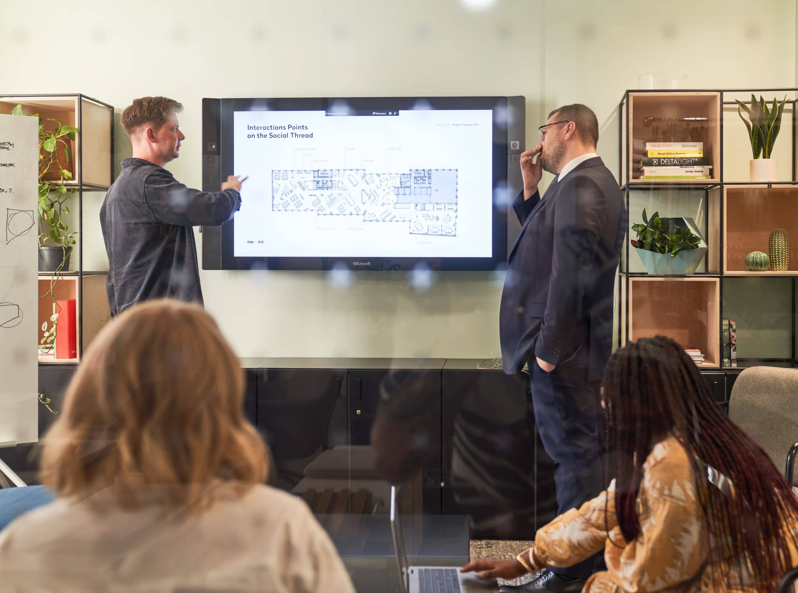 AIS design team in a meeting room collaborating over an office floor plan.