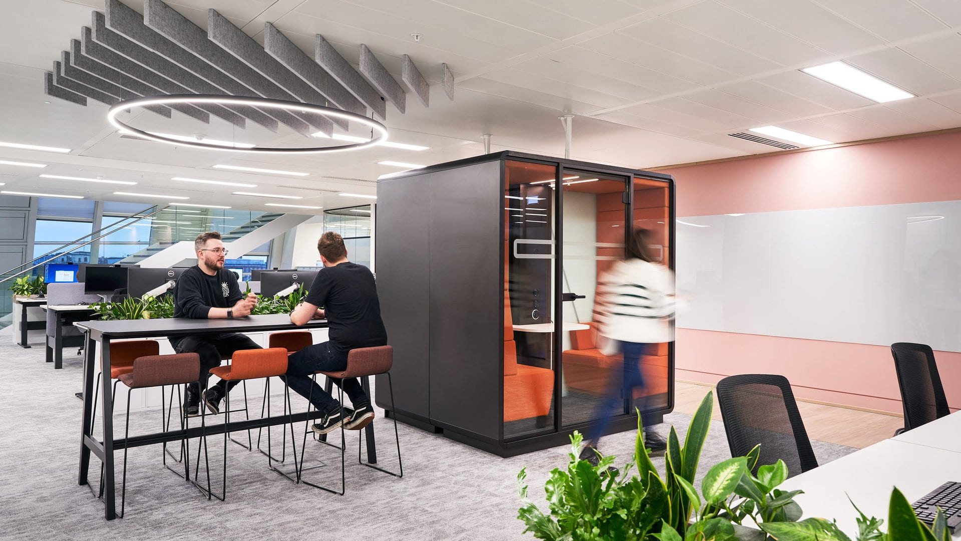 Employees are shown in an office that offers many different work settings which promotes neurodiversity.