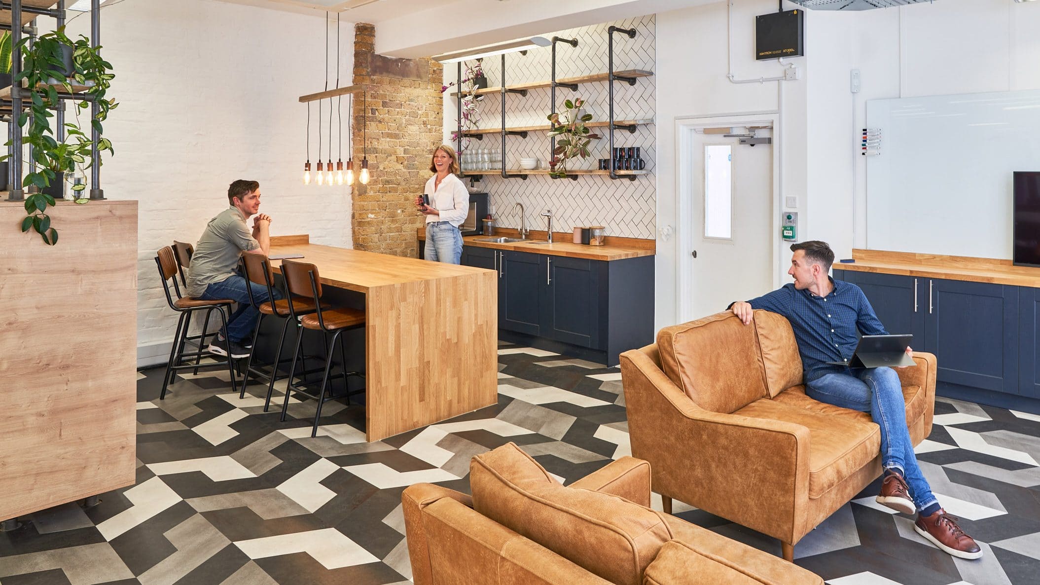 Millennial professionals participate in vibrant discussions within the contemporary kitchen breakout space, showcasing the latest Millennial workplace design trends.